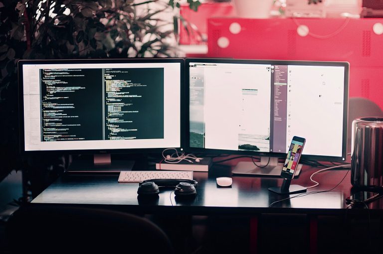 Escriptori amb dos monitors amb codi