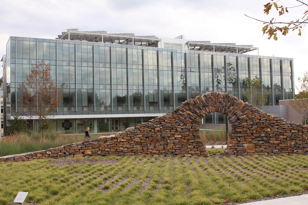 Edifici d’oficines de vidre envoltat de jardins