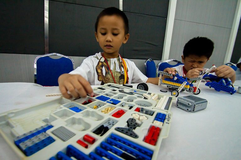 Infant construint un robot de peces