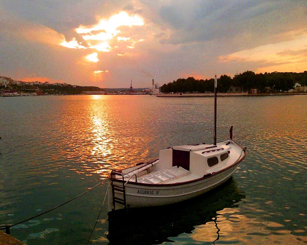Capvespre al port de Maó amb una barca
