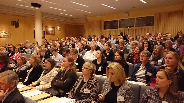 Sala d’actes amb públic i pantalla de projecció
